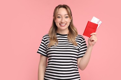 Photo of Happy young woman with passport and ticket on pink background