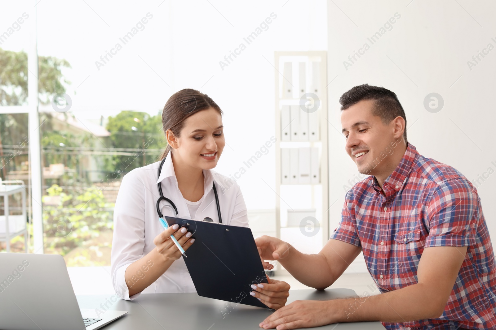 Photo of Young doctor consulting patient in modern hospital