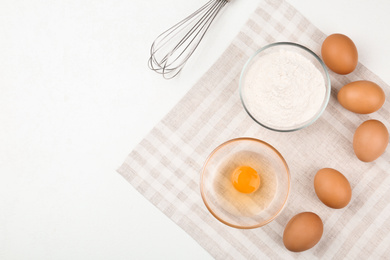 Photo of Flat lay composition with raw eggs and other ingredients on white table. Baking pie