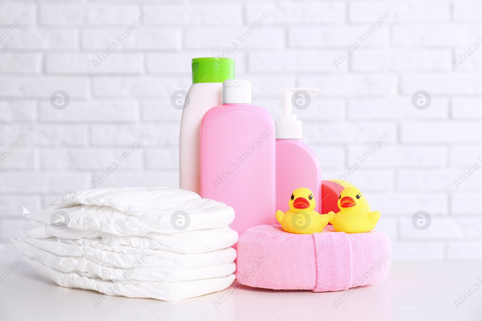 Photo of Baby accessories on table near white brick wall