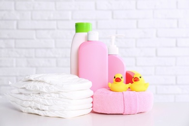 Baby accessories on table near white brick wall