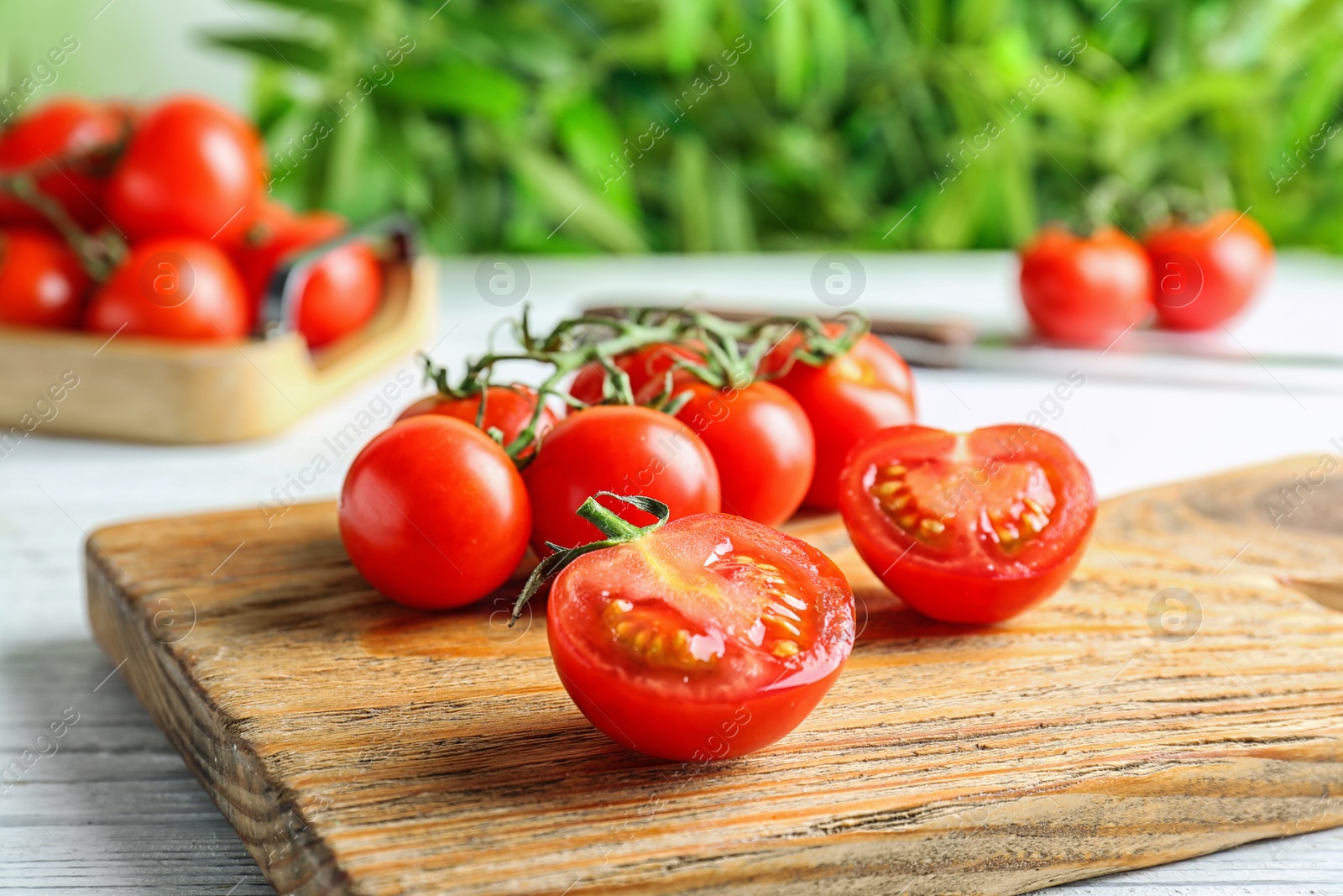 Photo of Wooden board with fresh ripe tomatoes on table