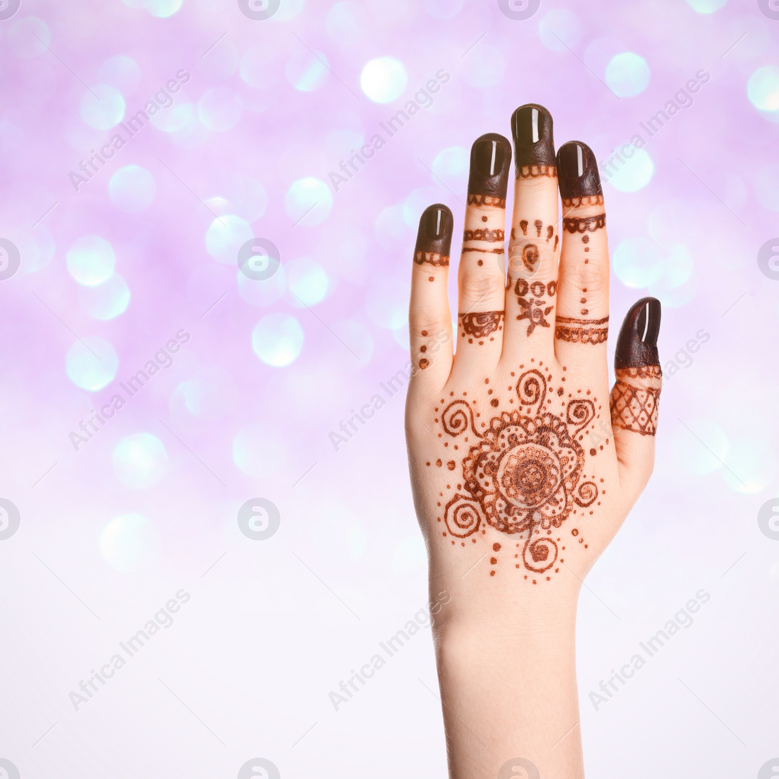 Image of Woman with henna tattoo on hand against blurred lights, bokeh effect. Space for text