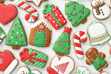 Photo of Many different delicious Christmas cookies on white wooden table, flat lay