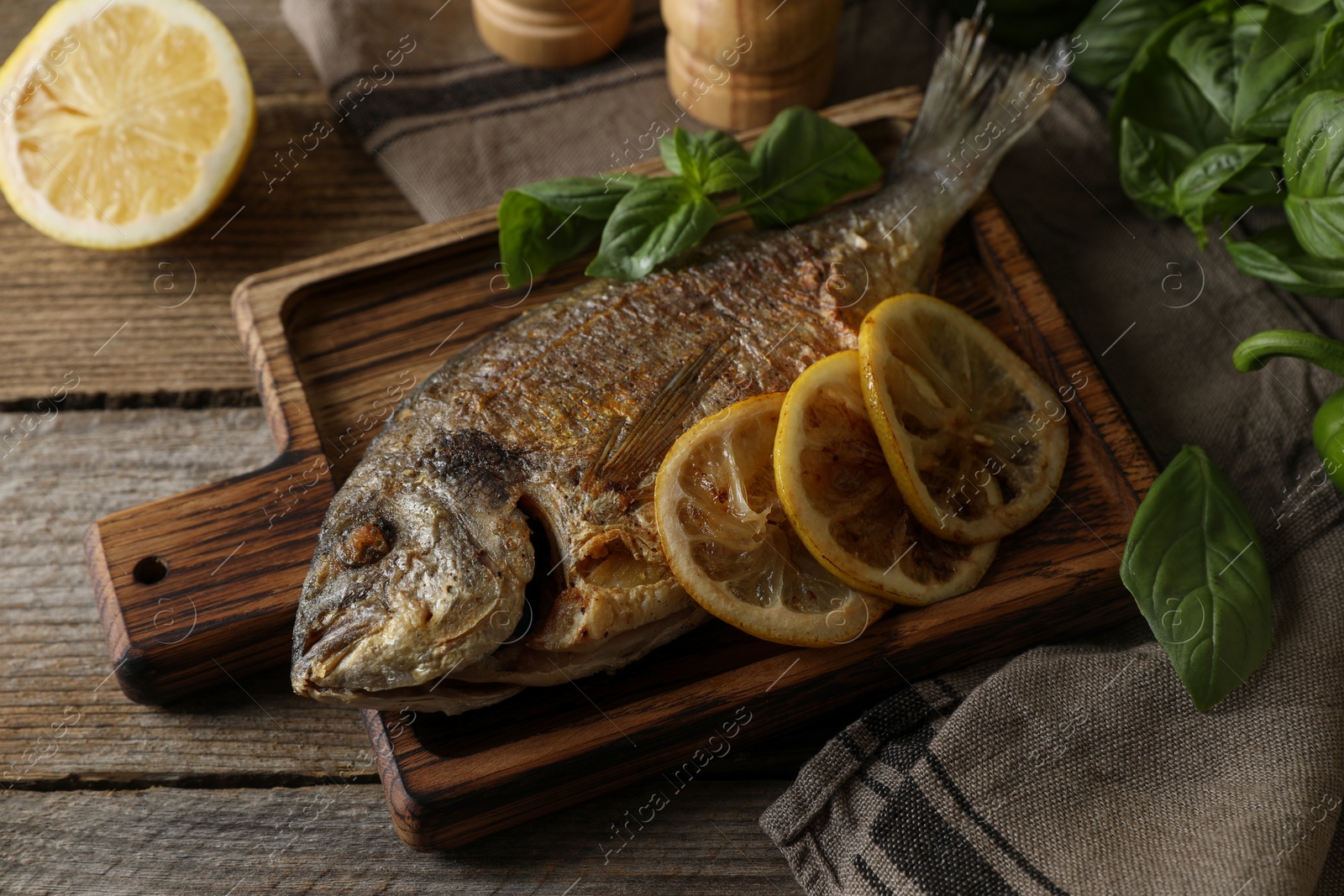 Photo of Delicious dorado fish served on wooden table