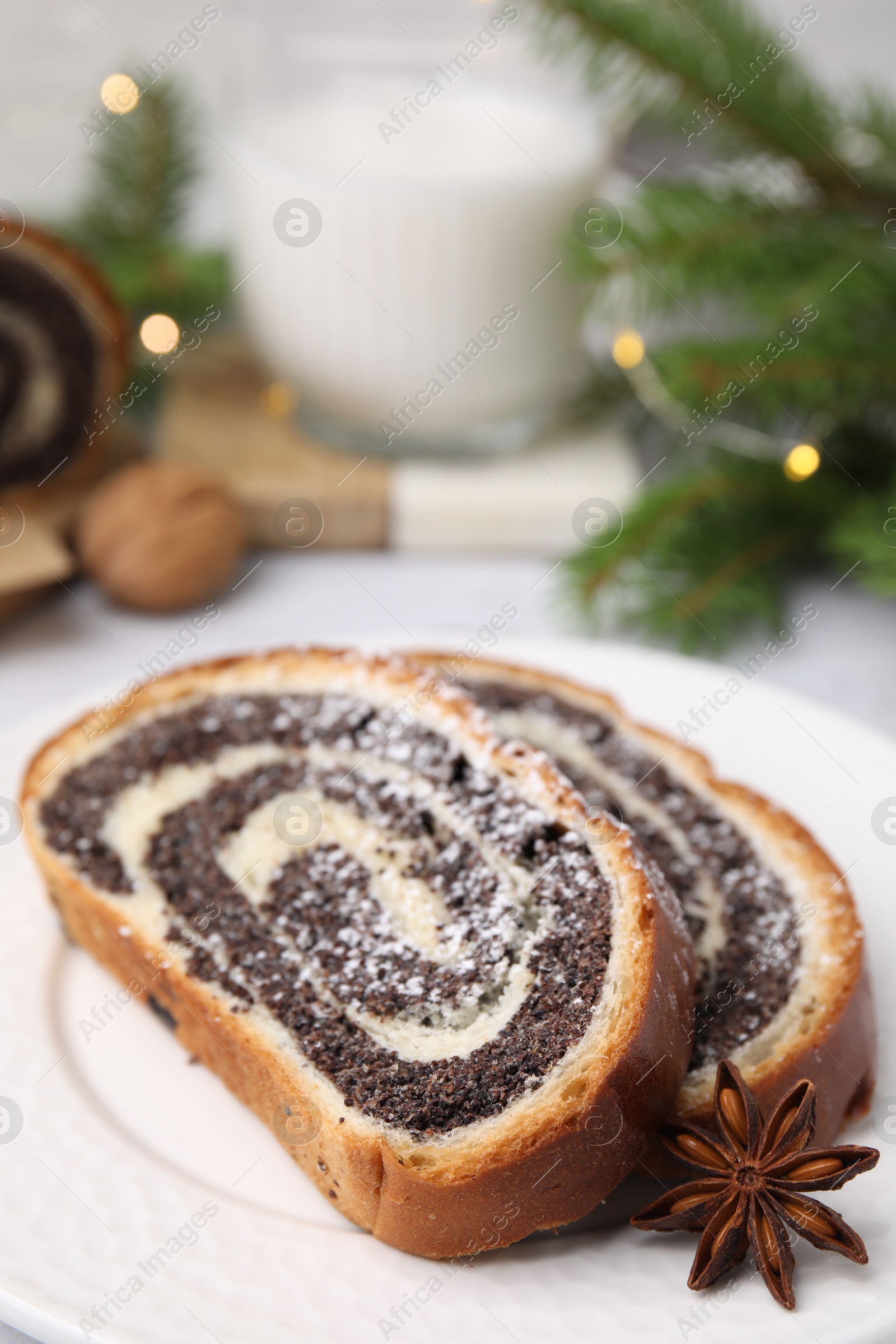 Photo of Slices of poppy seed roll and anise star on plate, closeup with space for text. Tasty cake