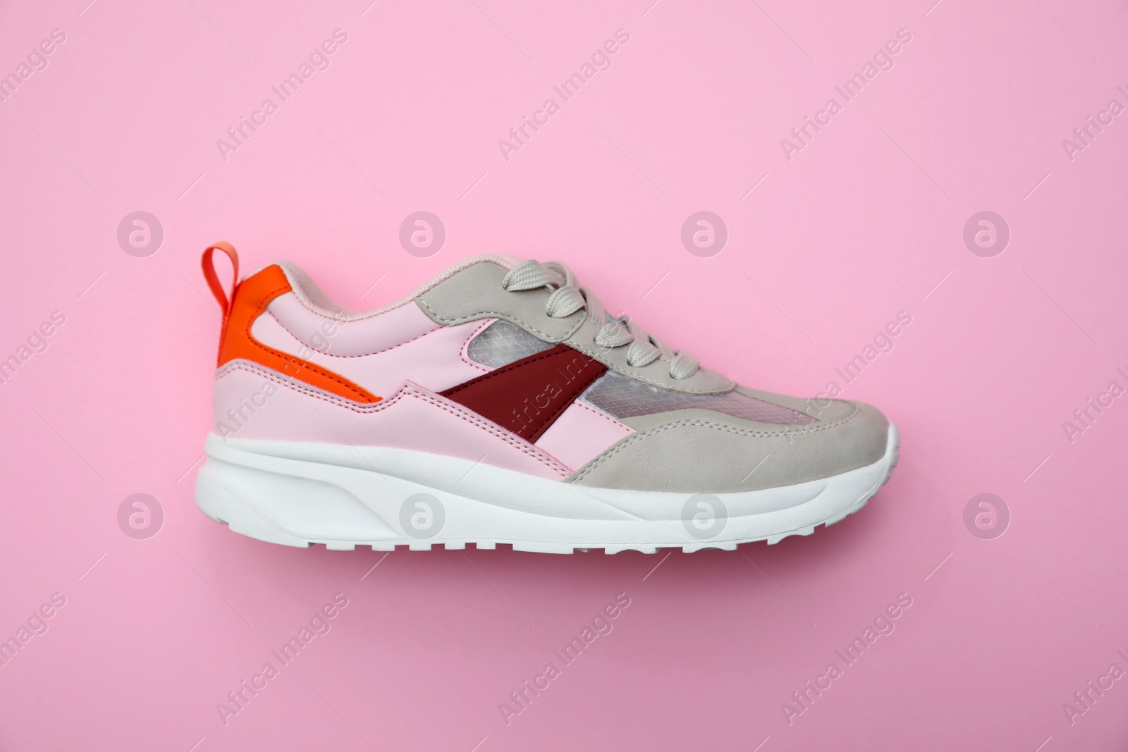 Photo of Stylish women's sneaker on pink background, top view