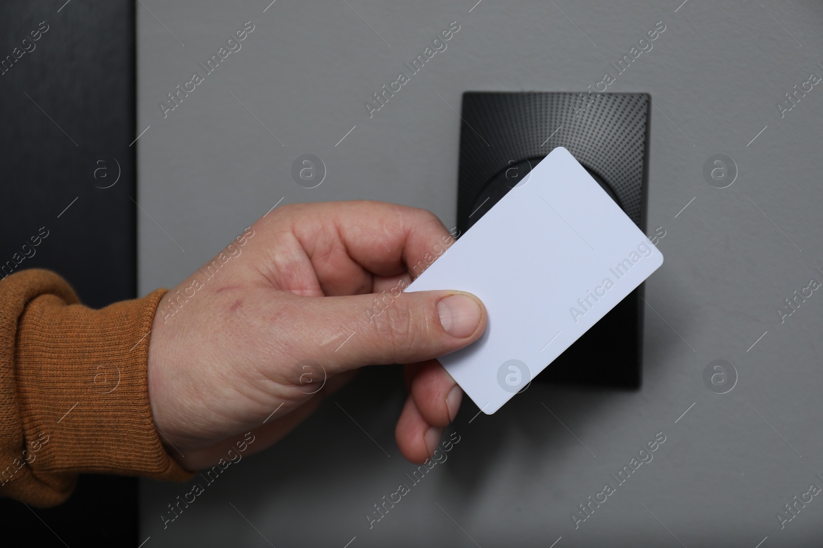 Photo of Man opening magnetic door lock with key card, closeup. Home security