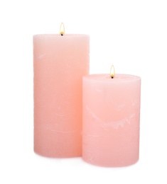Photo of Burning pink wax candles on white background