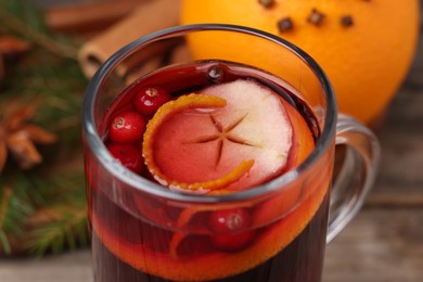 Photo of Aromatic mulled wine in glass cup on table, closeup