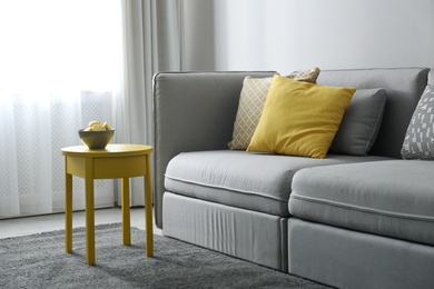 Stylish living room with sofa. Interior design in grey and yellow colors