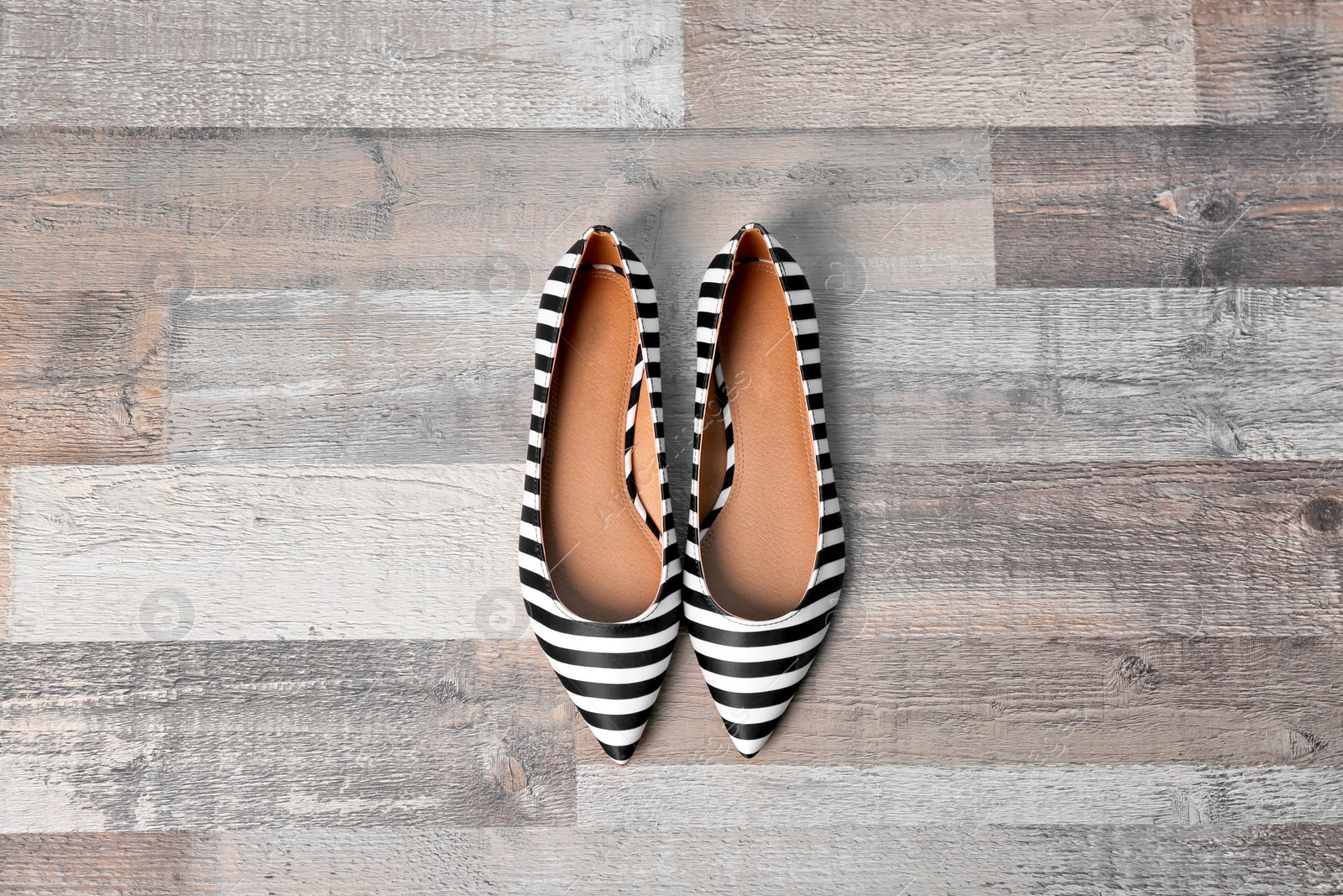 Photo of Pair of female shoes on wooden background, top view