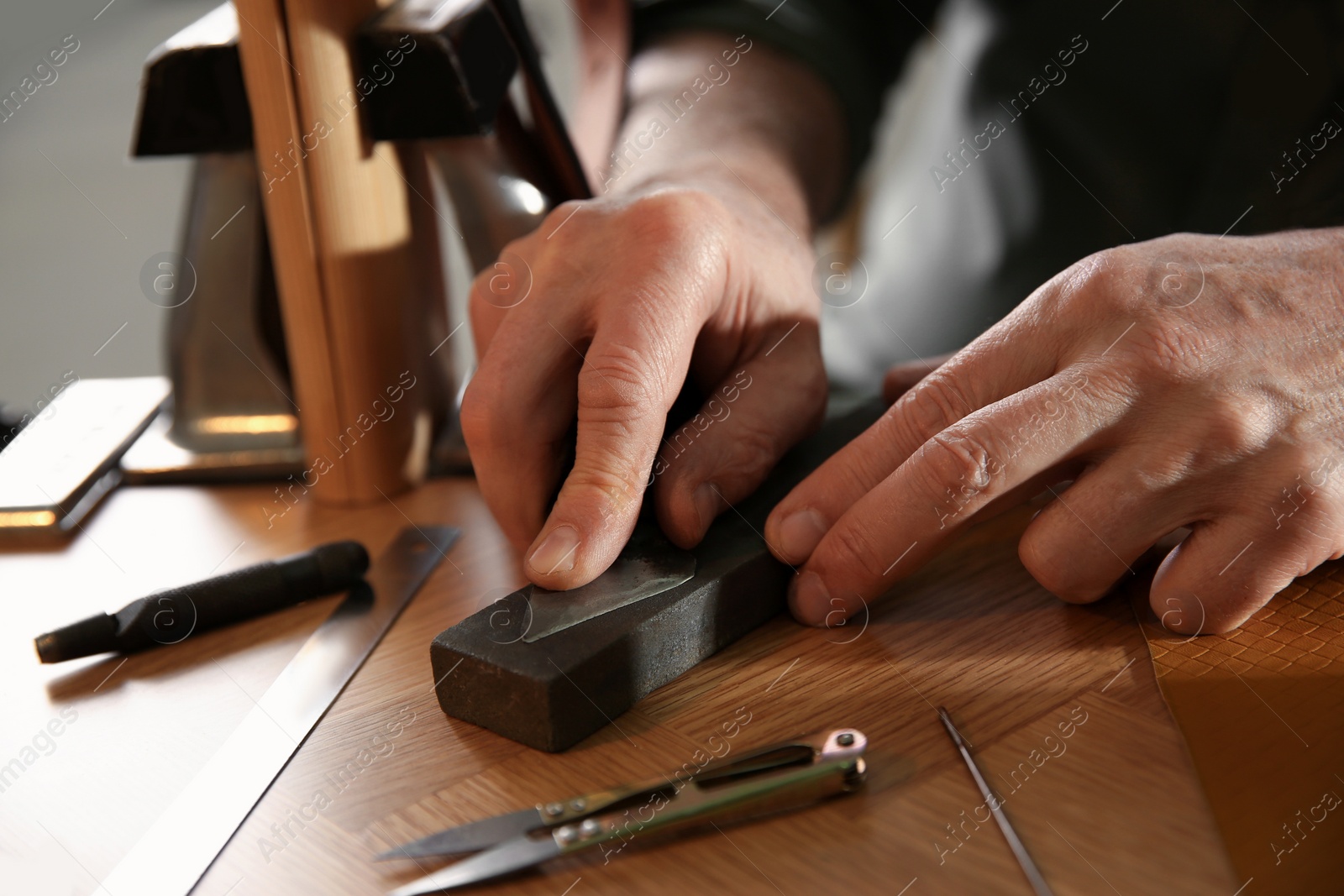 Photo of Man with tools for leather working, closeup