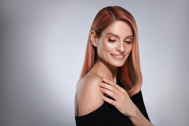 Image of Hair styling. Gorgeous woman with colorful hair on grey background