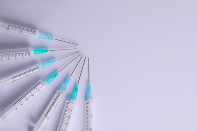 Disposable syringes with needles on white background, flat lay. Space for text