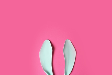 Funny Easter bunny ears on color background, top view with space for text