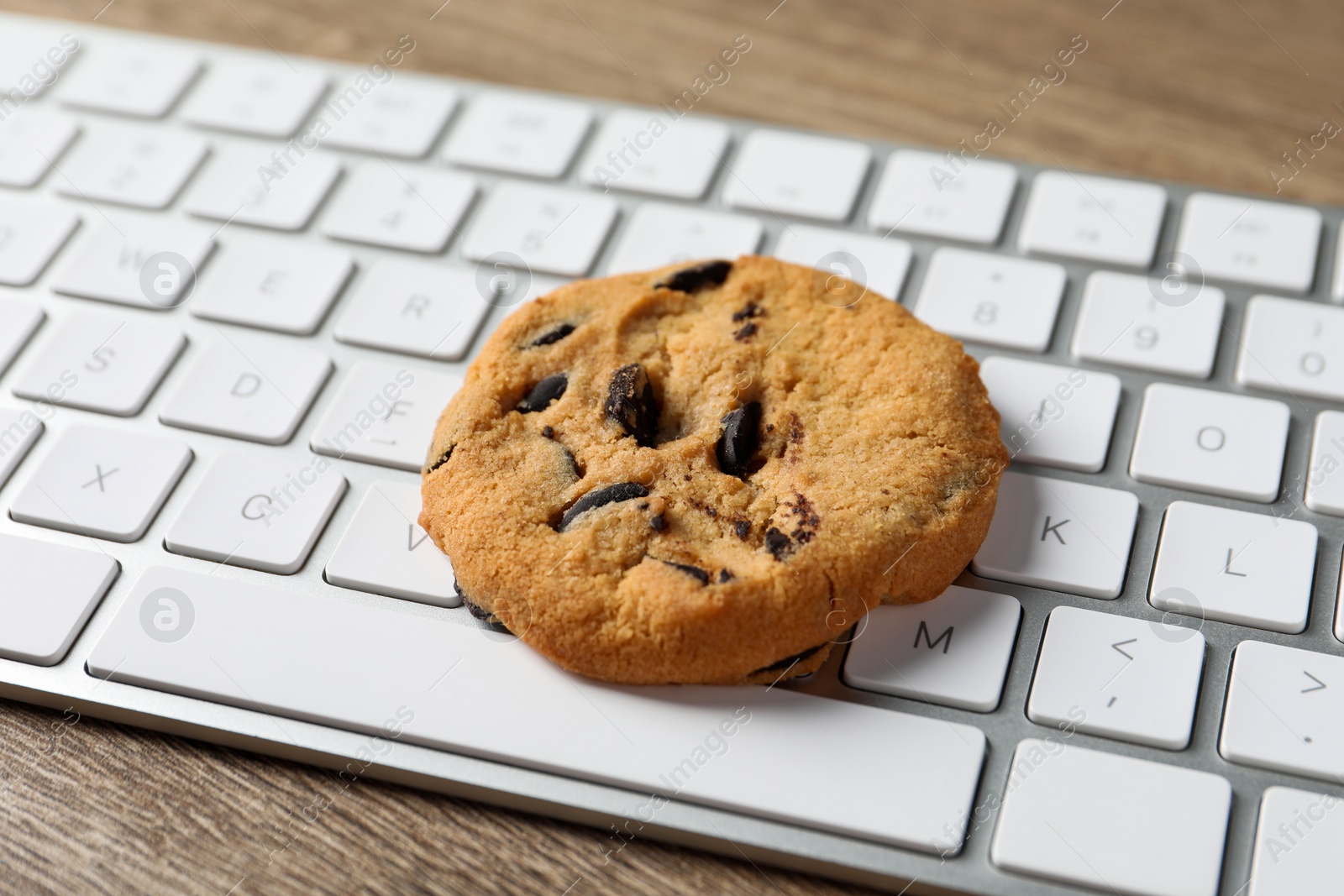 Photo of Chocolate chip cookie on keyboard, closeup view