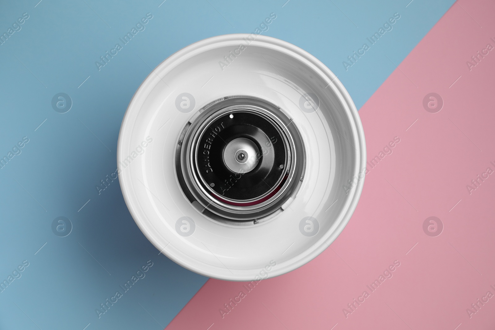 Photo of Portable candy cotton machine on color background, top view