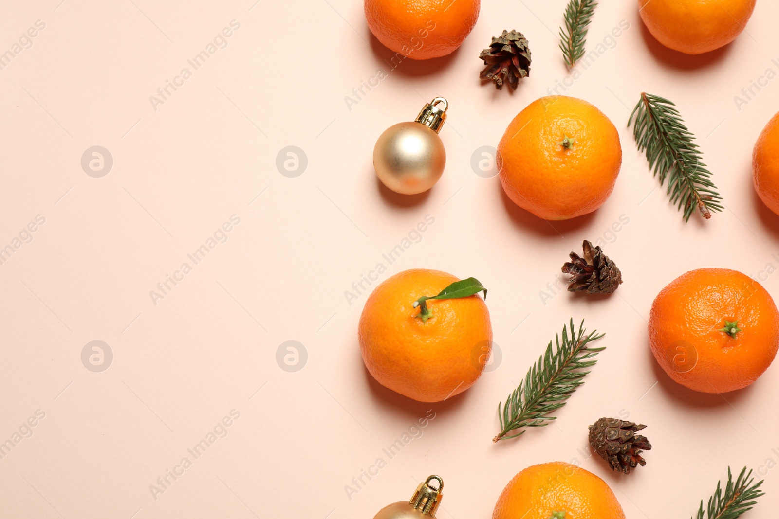 Photo of Composition with Christmas balls and tangerines on beige background, flat lay. Space for text