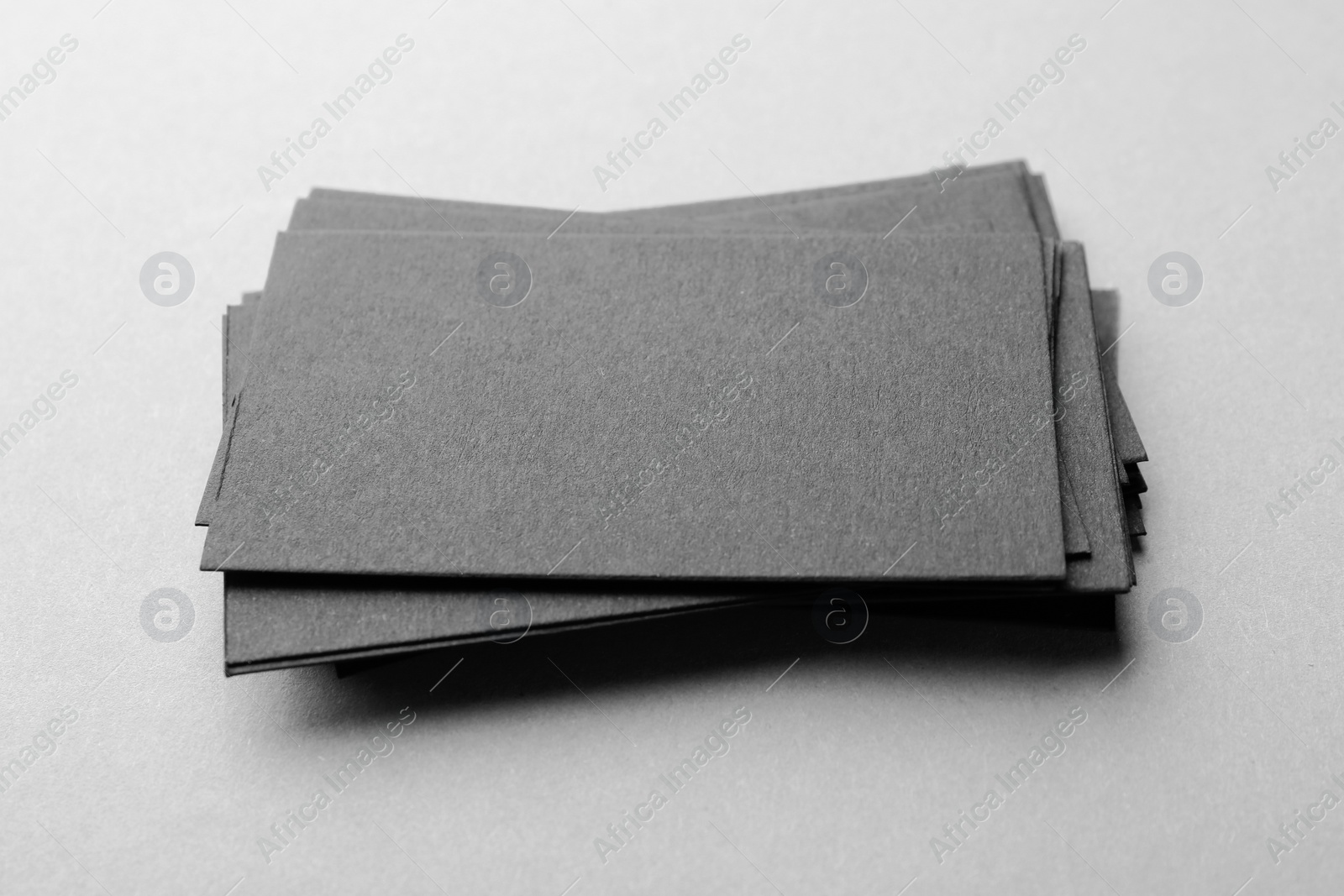 Photo of Blank black business cards on light background, closeup. Mockup for design