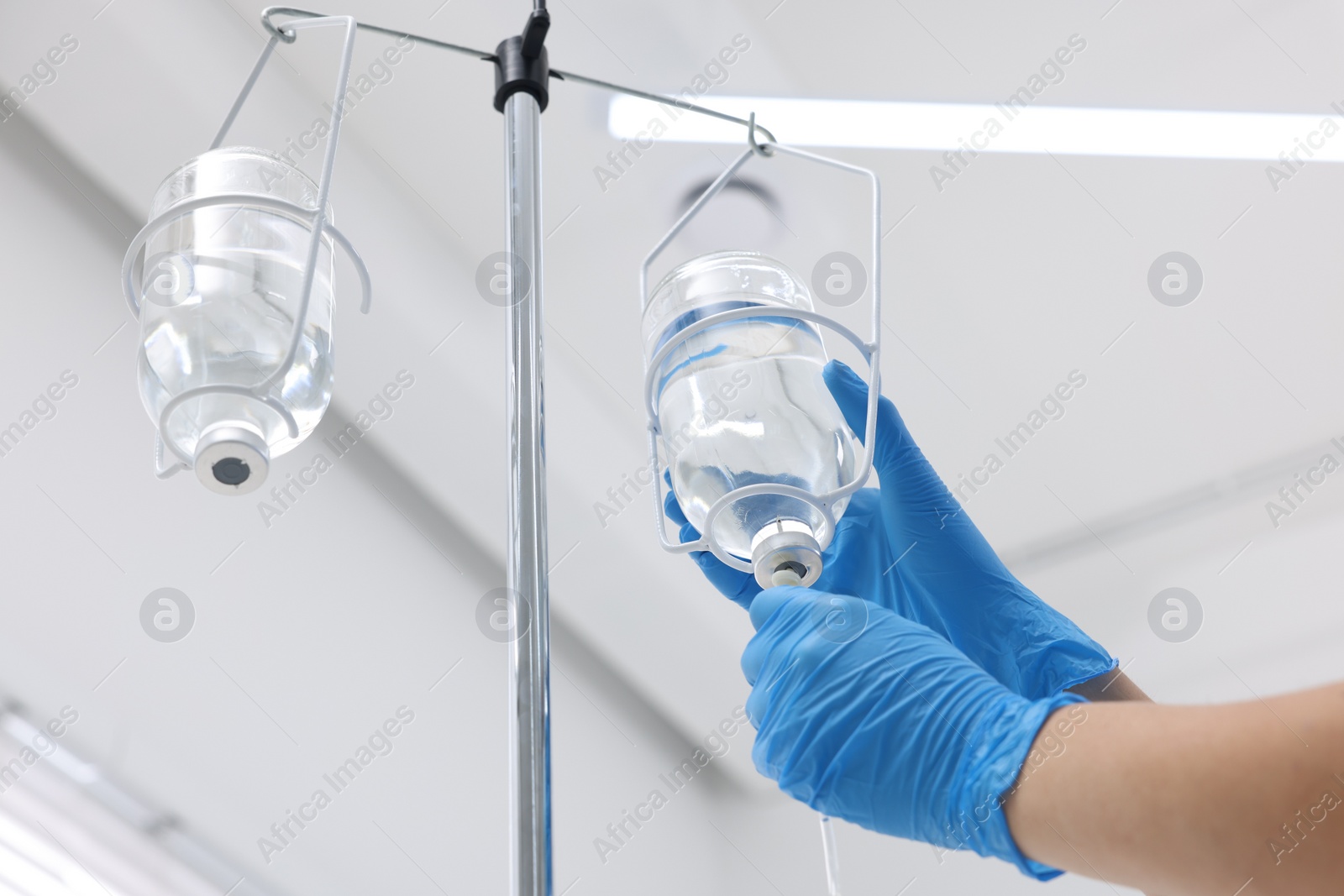 Photo of Nurse setting up IV drip in hospital, closeup