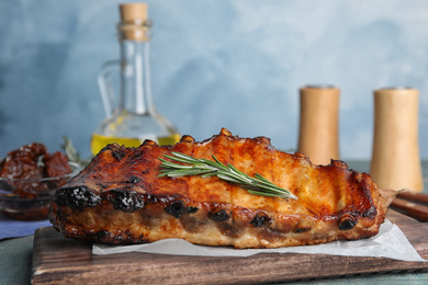 Tasty grilled ribs with rosemary on table