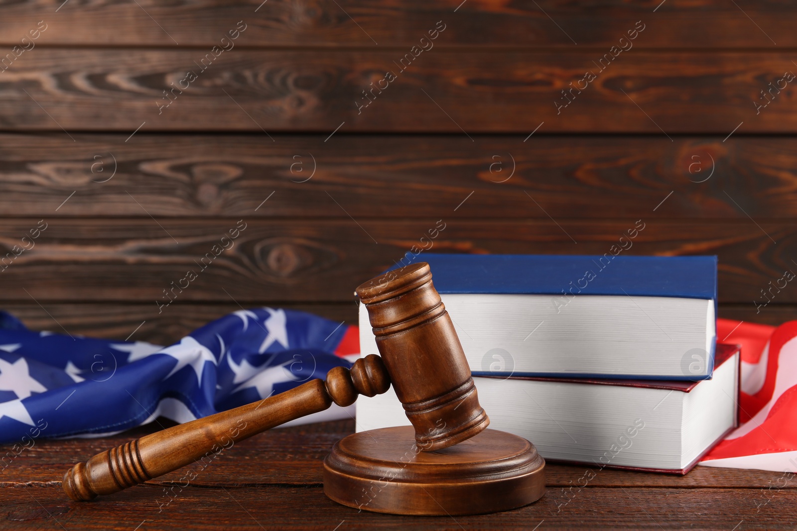 Photo of Judge's gavel, books and American flag on wooden table, space for text