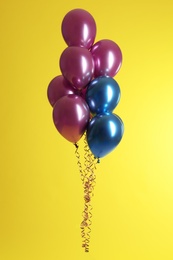 Bunch of bright balloons on color background