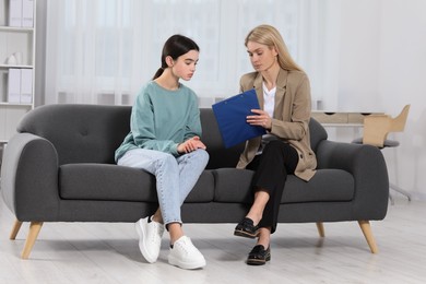 Psychologist working with teenage girl in office. Teenager problems