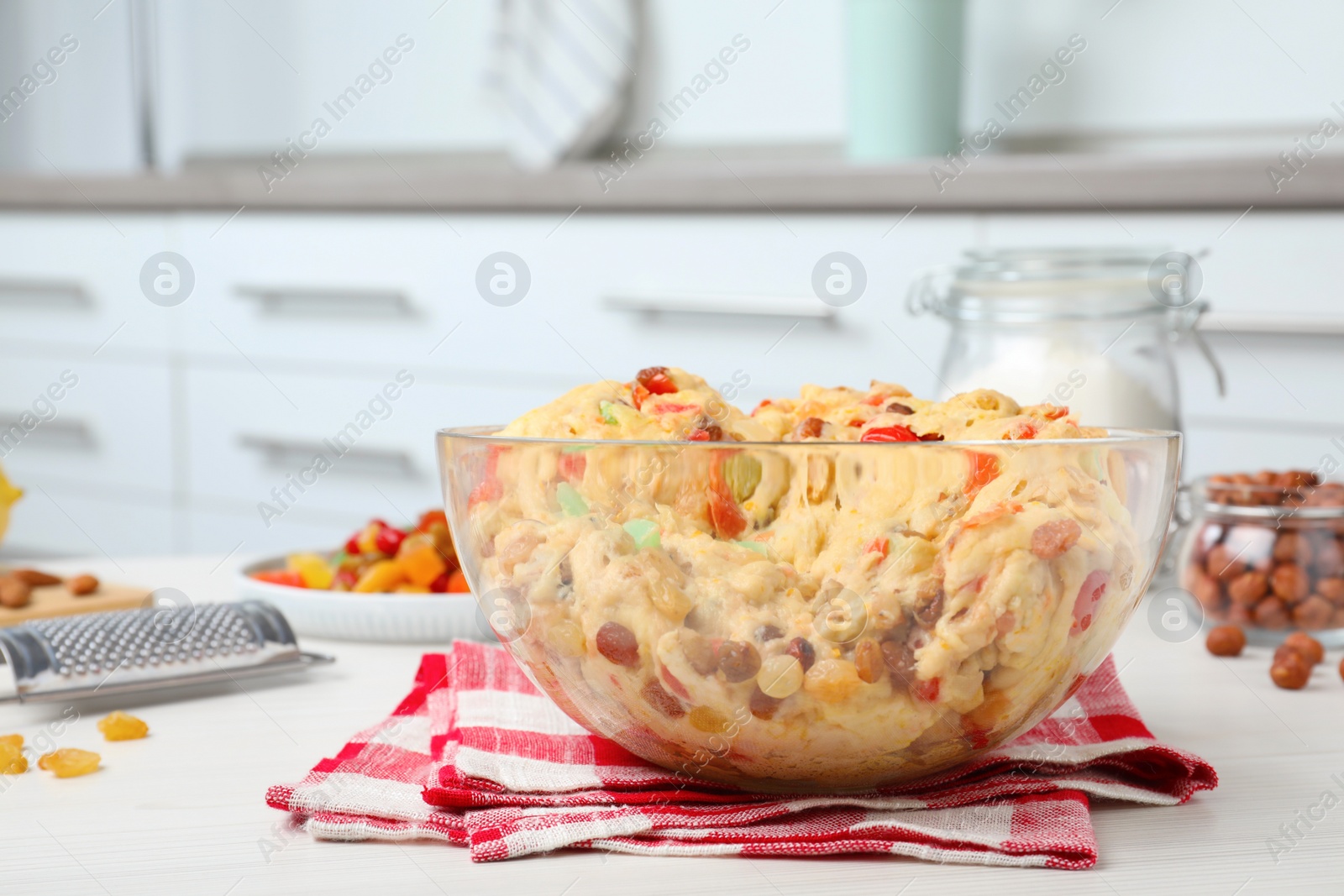 Photo of Raw dough with candied fruits and nuts for Stollen in bowl on white wooden table indoors. Baking traditional German Christmas bread