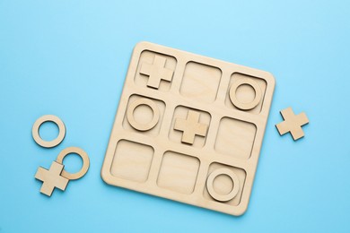 Photo of Tic tac toe set on light blue background, flat lay