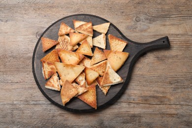 Delicious pita chips on wooden table, top view