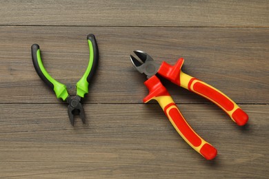 Two pliers on wooden table, flat lay