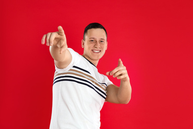 Photo of Happy handsome young man on red background