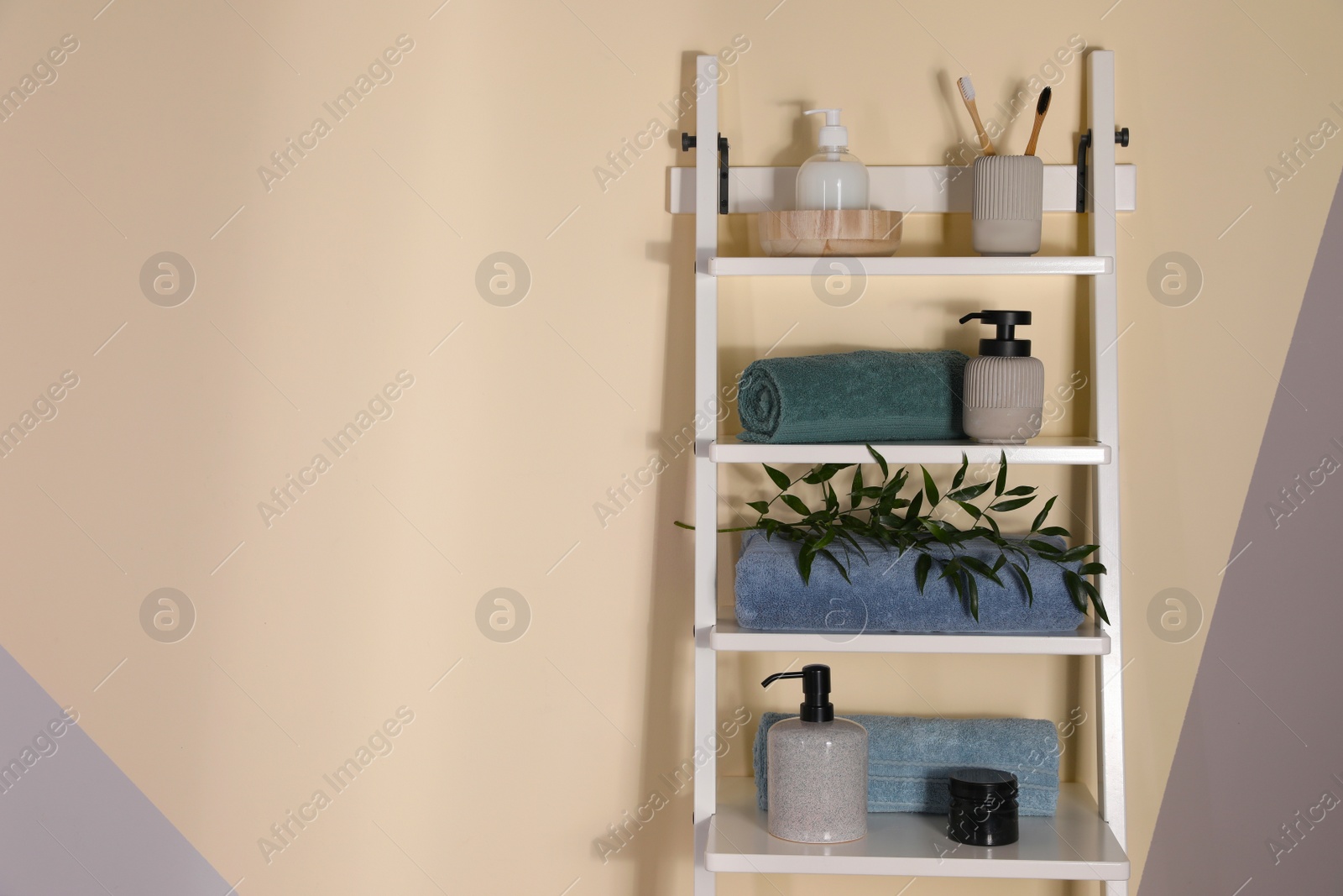Photo of Shelving unit with toiletries near light wall indoors, space for text. Bathroom interior element