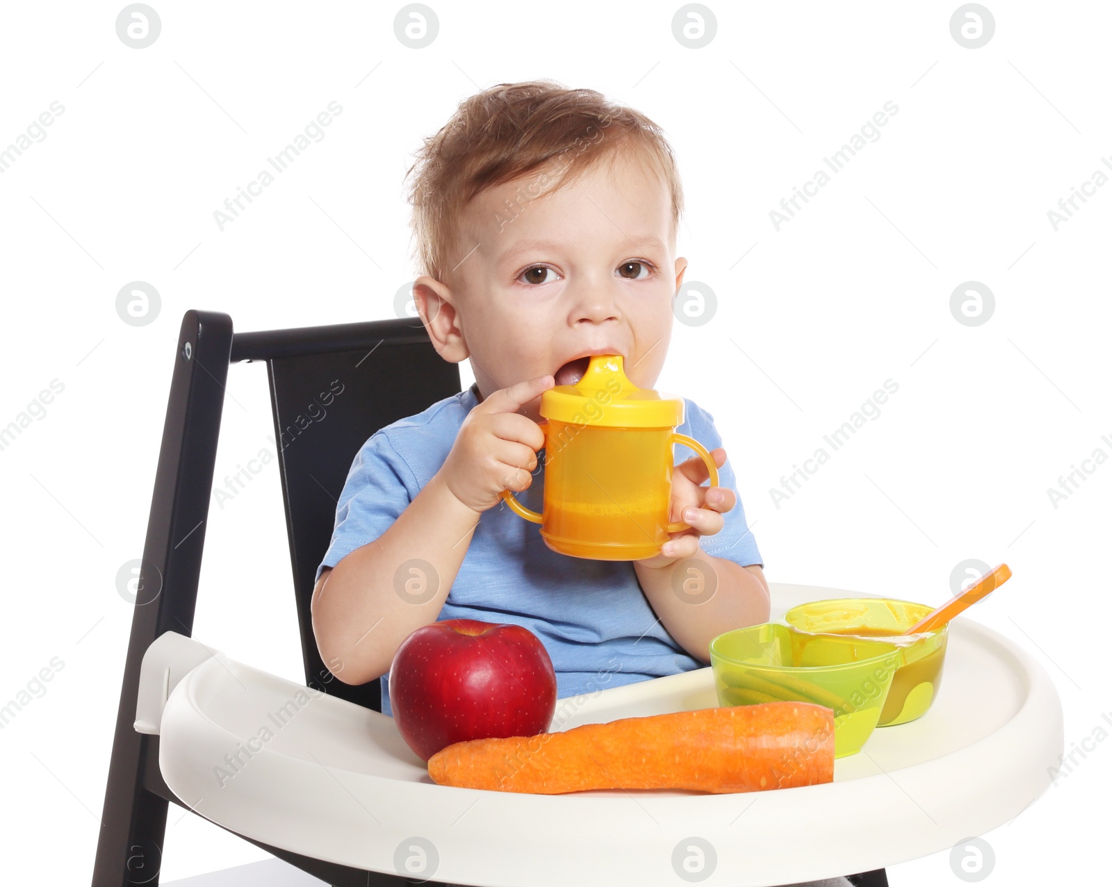 Photo of Adorable little child having breakfast in highchair against white background. Healthy baby food