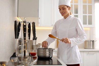 Professional chef cooking delicious dish in saucepan indoors