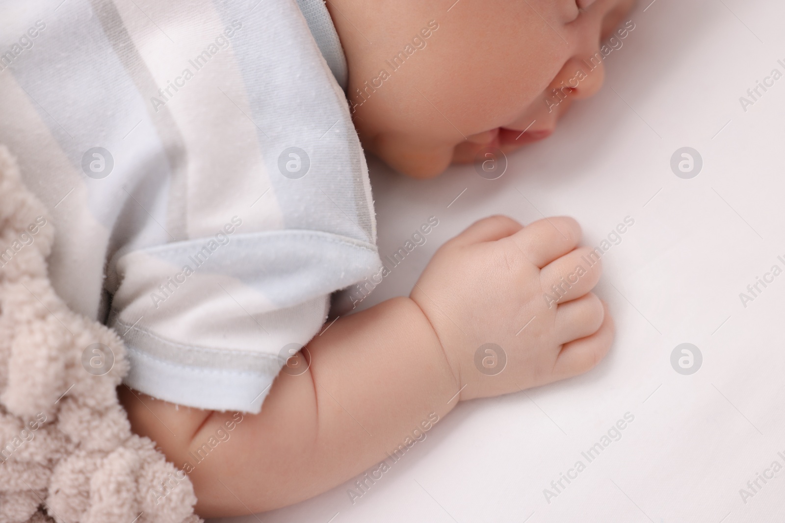 Photo of Cute newborn baby sleeping on white blanket, closeup