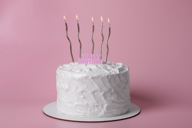 Photo of Delicious cake with cream and burning candles on pink background
