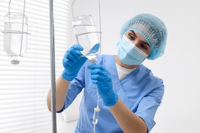 Photo of Nurse setting up IV drip in hospital