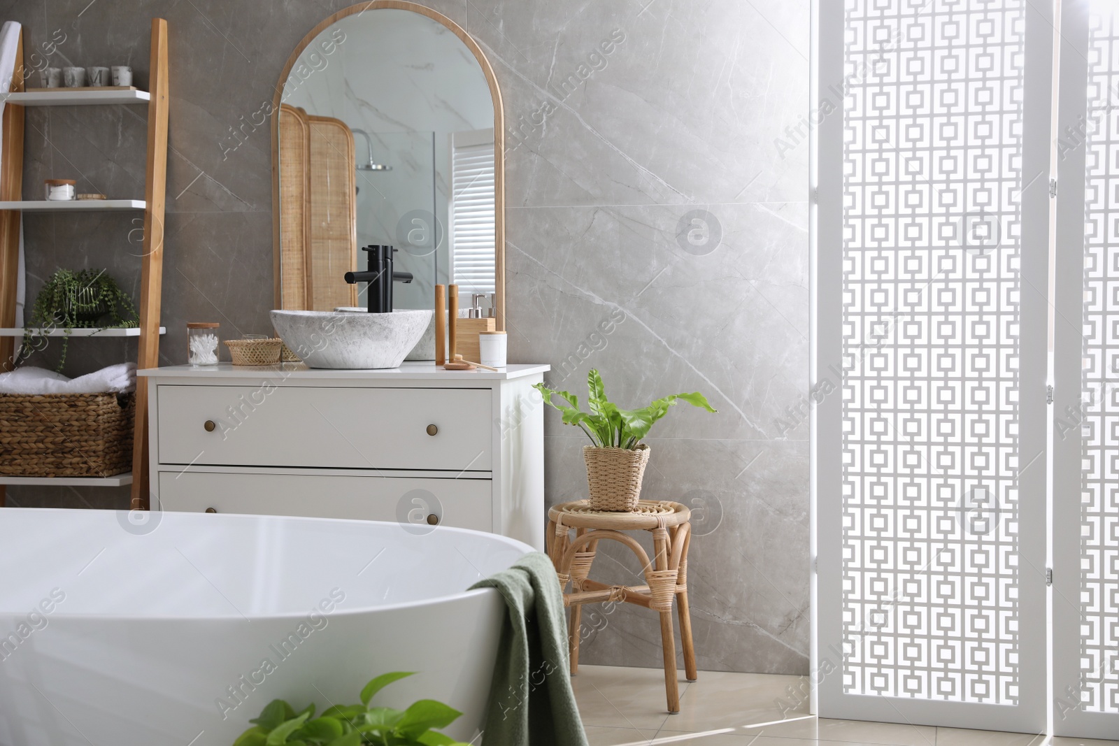 Photo of Modern white tub and chest of drawers with sink in bathroom. Interior design