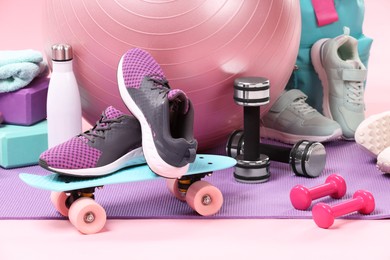 Many different sports equipment on pink background