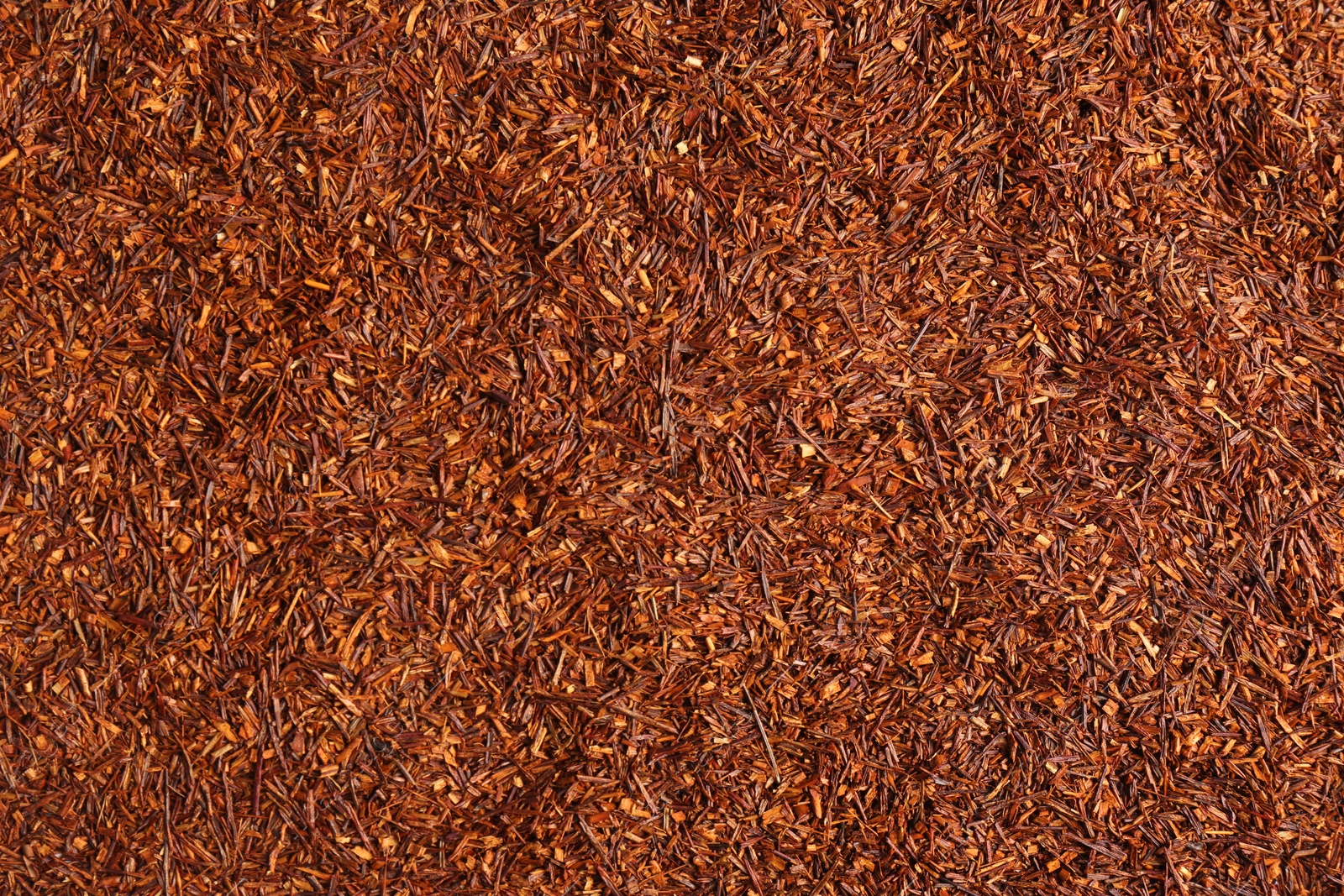 Photo of Heap of dry rooibos tea leaves as background, top view