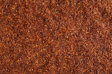 Photo of Heap of dry rooibos tea leaves as background, top view