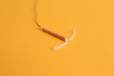 Photo of Copper intrauterine contraceptive device on yellow background