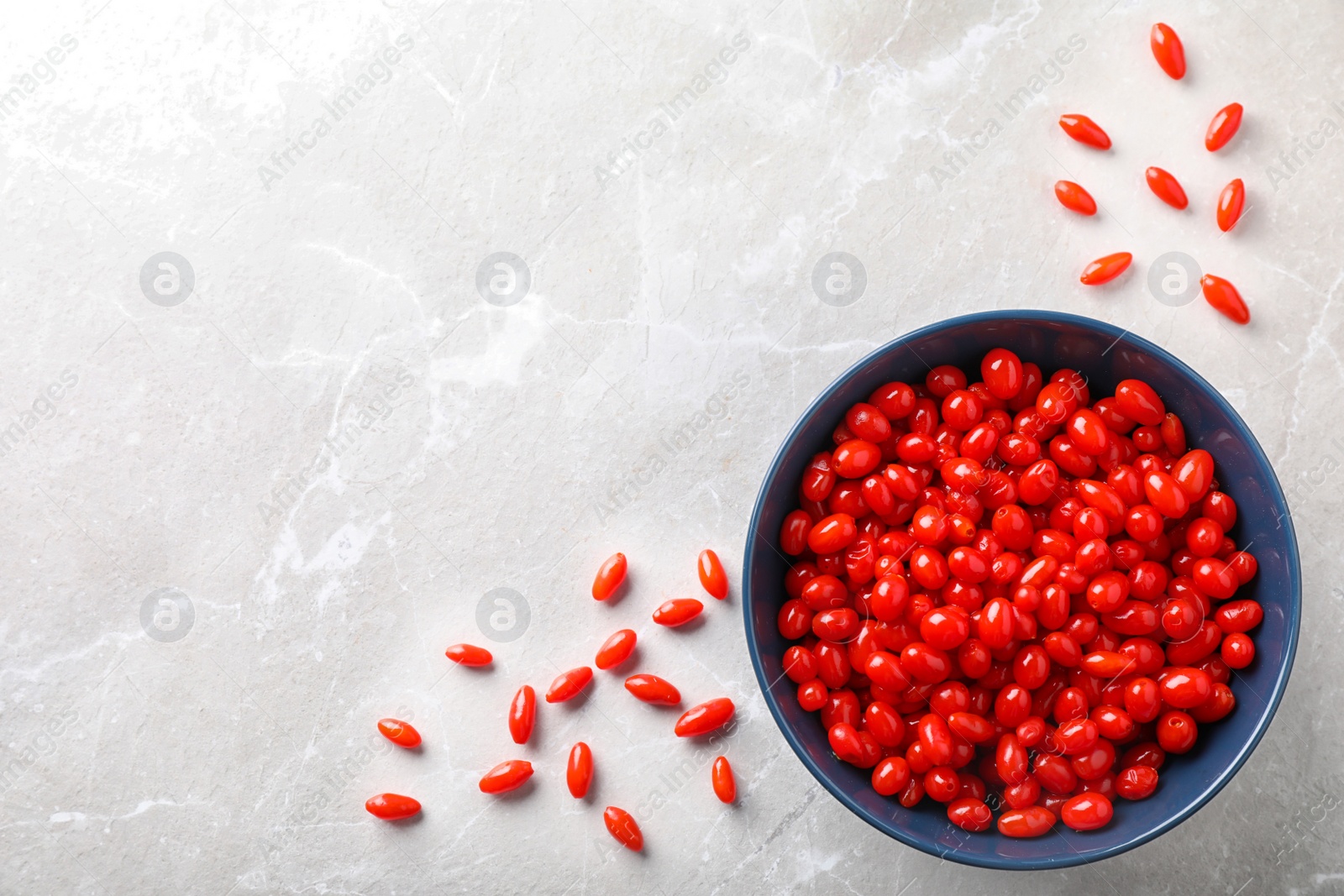 Photo of Fresh ripe goji berries on marble table, flat lay. Space for text