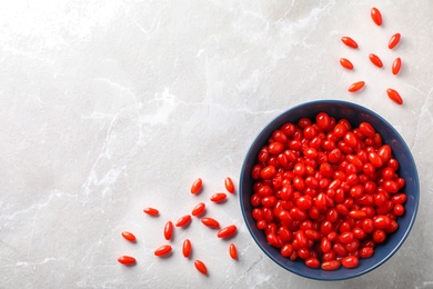 Fresh ripe goji berries on marble table, flat lay. Space for text