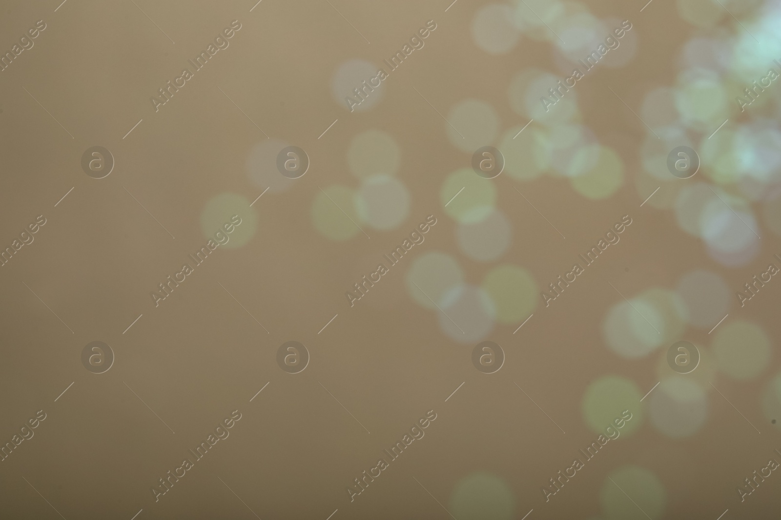 Photo of Blurred view of glitter on beige background. Bokeh effect