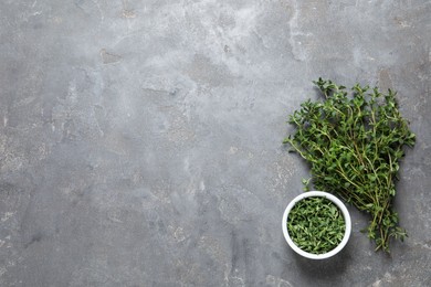 Photo of Aromatic thyme on grey table, flat lay. Space for text