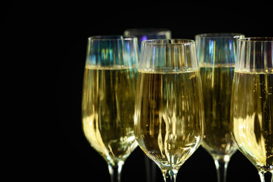 Photo of Glasses of champagne on black background, closeup